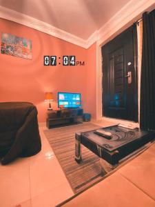a living room with a table and a tv in it at Layback apartment in 6 October city Cairo in 6th Of October