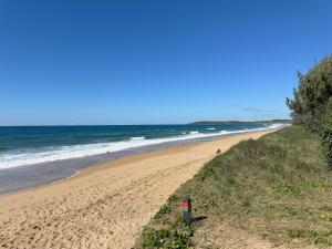 a sandy beach with people walking on it next to the ocean at 1770 Holiday Village in Seventeen Seventy