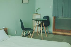 a bedroom with two chairs and a table and a bed at Hostel Mt. Fuji - FUKUYA in Fujiyoshida