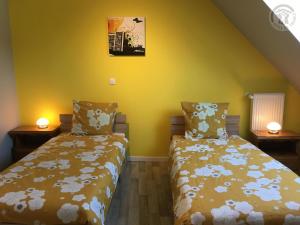 two beds in a room with yellow walls at Maison spacieuse pour 8 pers avec jardin, terrasse, WIFI, proche commerces et attractions culturelles - FR-1-510-156 in Aniche