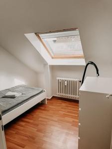 a small room with a bed and a skylight at Im Südviertel von Essen! FDG in Essen