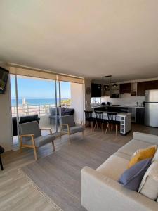a living room with a couch and a kitchen with a view at Depto en La Serena con vista al mar in La Serena