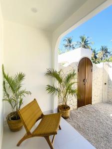 ギリ・トラワンガンにあるIsla Villas - Private Boutique Villasの椅子と鉢植えの植物2本が備わる部屋