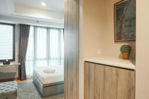 a bedroom with a bed and a window at Luxurious Studio at Capitol Suites Apartment By Travelio in Jakarta +14 photos
