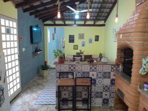 a kitchen with a counter and a brick fireplace at Cantinho do Paraíso in Águas de Lindóia