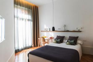 a bedroom with a large bed and a large window at Casa Mathilda in Barcelona