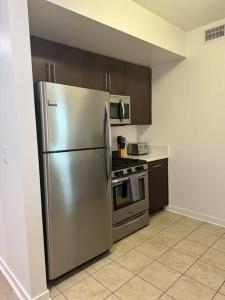 eine Küche mit einem Kühlschrank aus Edelstahl und einem Herd in der Unterkunft The Carlton - Modern-Lux 2 Master Suites-Secure Bldg & Parking- 5 BLKS to Ocean Ave in Los Angeles
