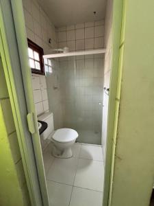 a small bathroom with a toilet and a window at Pousada Vida Mansa in Porto De Galinhas