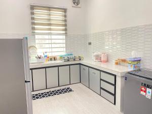 a kitchen with a sink and a counter top at Kak Hae Homestay in Tumpat
