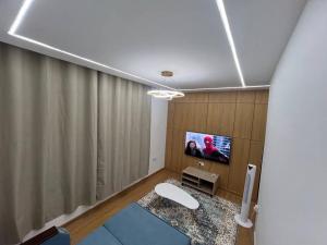 アジュマーンにあるElite Horizon Ajman Residenceのリビングルーム(壁にテレビ付)