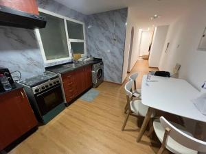 アジュマーンにあるElite Horizon Ajman Residenceのキッチン(コンロ、テーブル、椅子付)