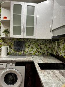 a kitchen with a washing machine in a kitchen at Эксклюзивная квартира для гостей г Караганда in Karagandy +13 photos