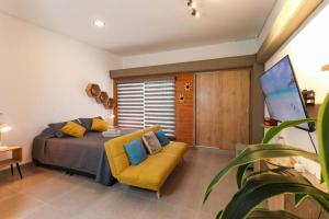 a bedroom with a bed and a yellow couch at Apartamento amoblado en Carepa cerca al aeropuerto in Carepa