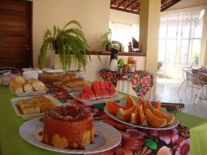 une table avec différents types de denrées alimentaires sur les assiettes dans l'établissement Pousada O Tabuleiro, à Jacumã