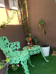 a green chair and a table with a potted plant at bleesed House aeropuerto in Monte Adentro