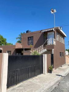 a house with a black fence in front of it at bleesed House aeropuerto in Monte Adentro