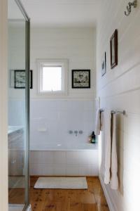 ein weißes Badezimmer mit Badewanne und Fenster in der Unterkunft Isabella at Kyneton in Kyneton + 51 Fotos