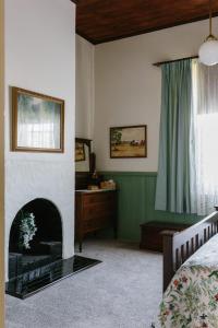 ein Schlafzimmer mit Kamin und Bett in der Unterkunft Isabella at Kyneton in Kyneton