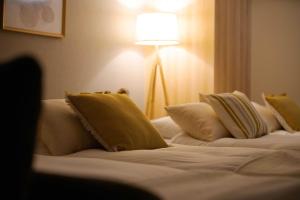 a bedroom with two beds with pillows and a lamp at TAKUTO STAY SAKAISUJI-HOMMACHI in Osaka