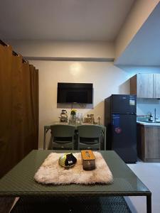 Una pequeña cocina con una mesa y un refrigerador. en RRS Cabin, Primeworld District, en Lapu Lapu City