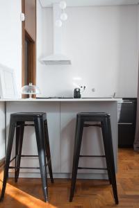 dos taburetes negros sentados en el mostrador de la cocina en Nidos Accommodation Gaia, en Vila Nova de Gaia