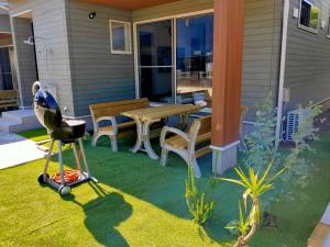 a patio with a table and chairs and a grill at 2022新築pleasant stay 海徒歩3分BBQ焚火 in Ichinomiya