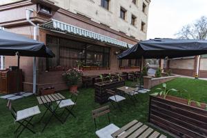 a patio area with chairs, tables and umbrellas at Alma in Almaty
