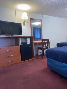 a living room with a flat screen tv and a blue couch at Swiss Cottage Inn in Niagara Falls