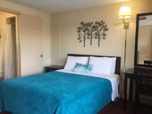 a bed in a hotel room with a blue blanket at Swiss Cottage Inn in Niagara Falls +17 photos