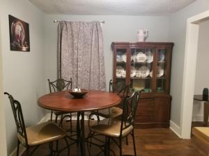 a dining room table with chairs and a china cabinet at Private Room in Cozy home in Memphis +1 photo