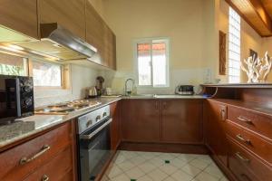 eine Küche mit Holzschränken und einem Herd mit Backofen in der Unterkunft V235 Huge Pool 4 Mins Kamala Beach 12 Mins Patong in Kamala Beach