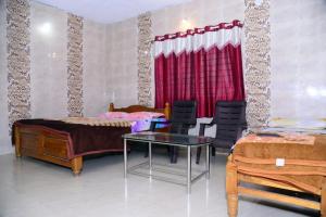 a bedroom with two beds and a table and chairs at SRI RANGA RESIDENCY in Māvingundi