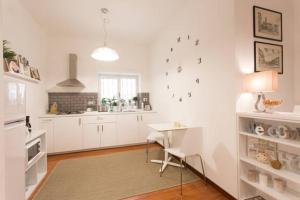 una cucina con mobili bianchi e un tavolo e una sala da pranzo di Le Coq Suites a Roma