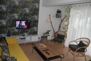 Una sala de estar con un sofá y un televisor en una pared. en Mzelle Pipine, en Saint-Pierre