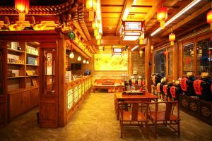 a restaurant with tables and chairs in a room at 晋悦庆会馆 in Pingyao