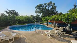 a swimming pool with white chairs and a group at Vesta Riviera - Free Parking in Golden Sands