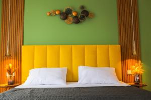 a bedroom with a bed with a yellow headboard at Mohika Boutique Aparthotel in Tbilisi City