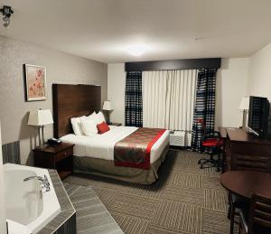 ムースジョーにあるRamada by Wyndham Moose Jawのベッドとバスルームがあるホテルの部屋