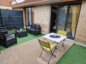 サン・タマン・モンロンにあるgrand Studio 2 personnesのパティオ(芝生の上にテーブルと椅子付)