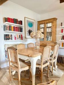 a dining room table with chairs and a vase with flowers at Maison bucolique champs de blé in Villers-Agron-Aiguizy