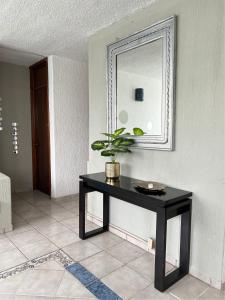 a table in a room with a mirror and a plant at Huatulco Nice Apartment A 10 Minutos de la Playa in Santa Cruz Huatulco