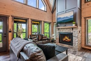 ein Wohnzimmer mit Couch und Kamin in der Unterkunft Smoky Bear Vista Brand New Luxury Cabin One Mile from Downtown Gatlinburg in Gatlinburg