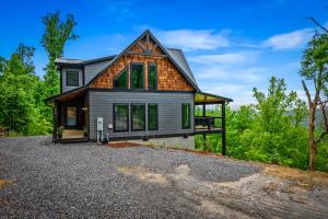 ein Haus auf einem Schotterplatz mit Bäumen in der Unterkunft Smoky Bear Vista Brand New Luxury Cabin One Mile from Downtown Gatlinburg in Gatlinburg