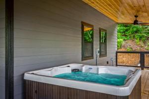 eine Badewanne auf der Seite eines Hauses in der Unterkunft Smoky Bear Vista Brand New Luxury Cabin One Mile from Downtown Gatlinburg in Gatlinburg + 89 Fotos