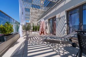 a patio with chairs and umbrellas on a building at HOTEL KALYA in Năvodari