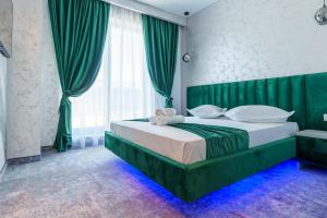 那沃达利HOTEL KALYA的卧室里有一张大床，床头板是绿色的