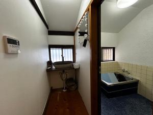 ein kleines Badezimmer mit Waschbecken und Spiegel in der Unterkunft Calmbase西伊豆STAGE in Numazu