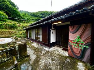ein Gebäude mit einem Schild an der Seite in der Unterkunft Calmbase西伊豆STAGE in Numazu