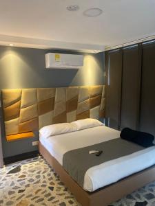 佩雷拉HOTEl AIRPORT PEREIRA的一间卧室配有一张大床和床头板