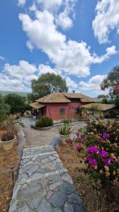 a stone walkway in front of a house with flowers at Nectar Cottages in Varákkes